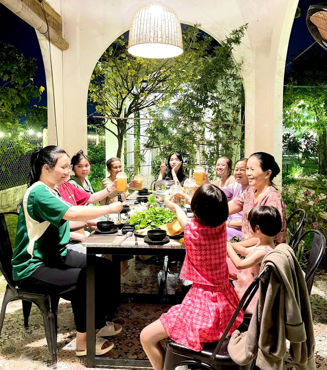 Gia đình nâng ly tại Thế Giới Lẩu Chay Sắc Màu Trảng Bàng - không gian arch đêm hoa lá